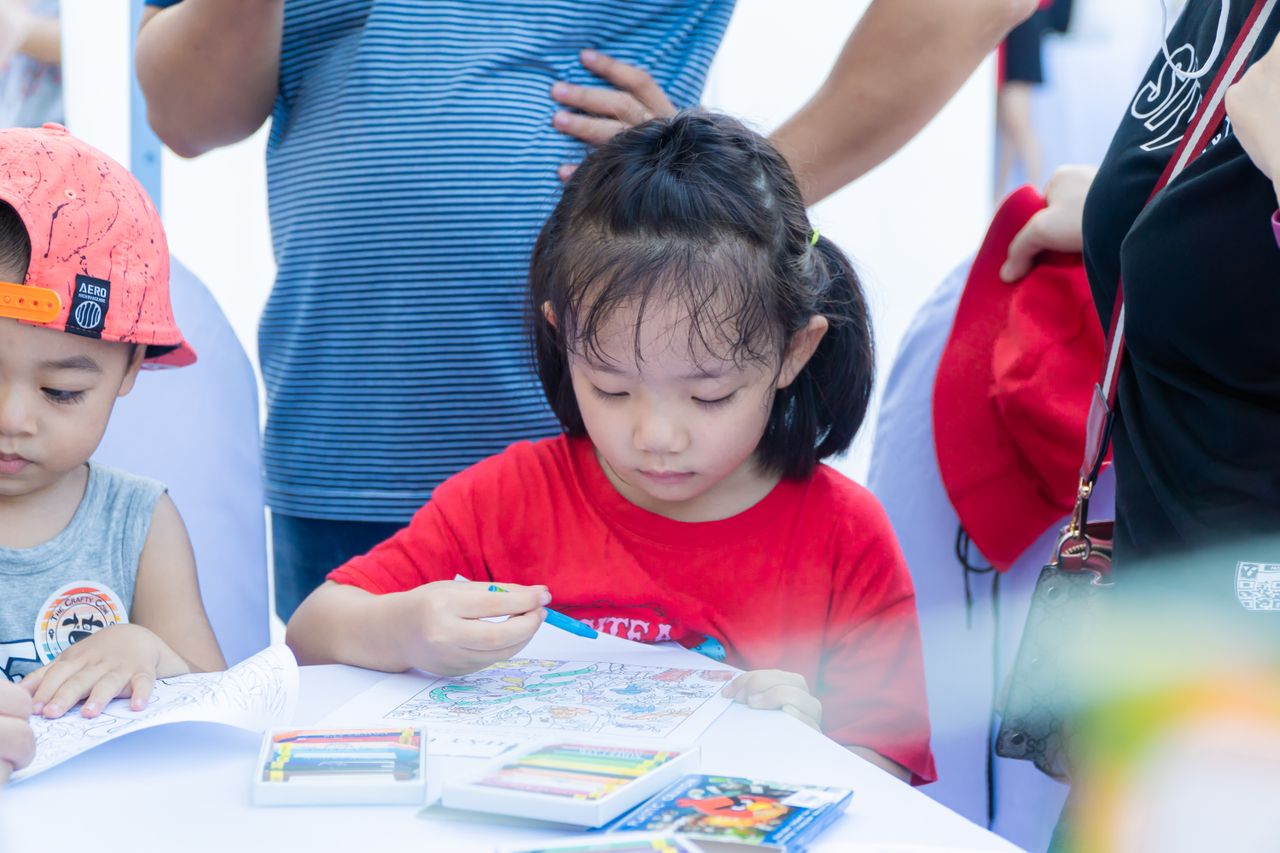 services-02 Young children enjoying a coloring activity with crayons at a table, focused and creative.